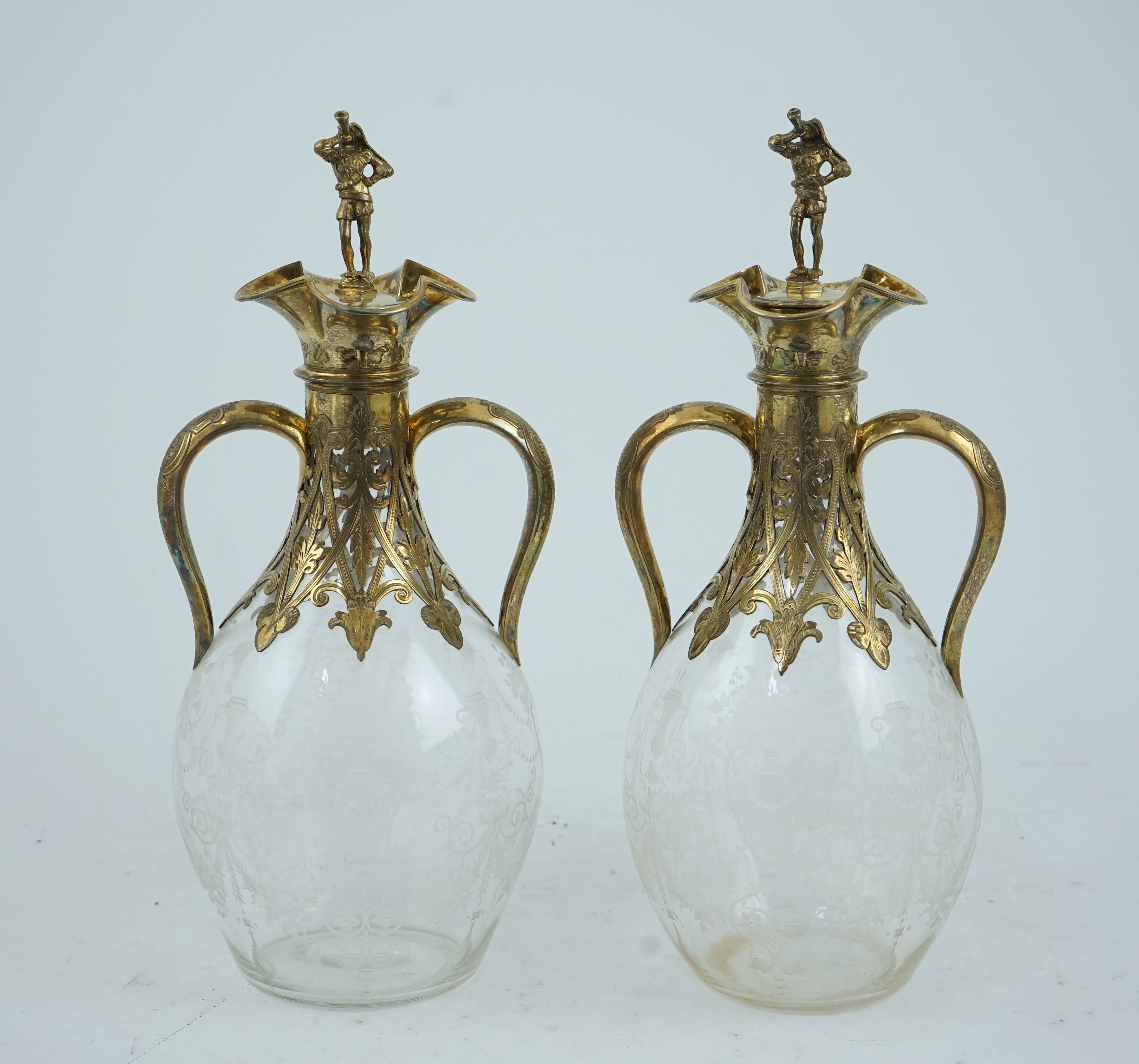 A good pair of Victorian silver gilt mounted wheel engraved glass two handled decanters and stoppers, by George Fox